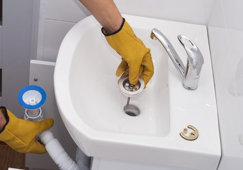 plumber installs a new plastic siphon on the sink